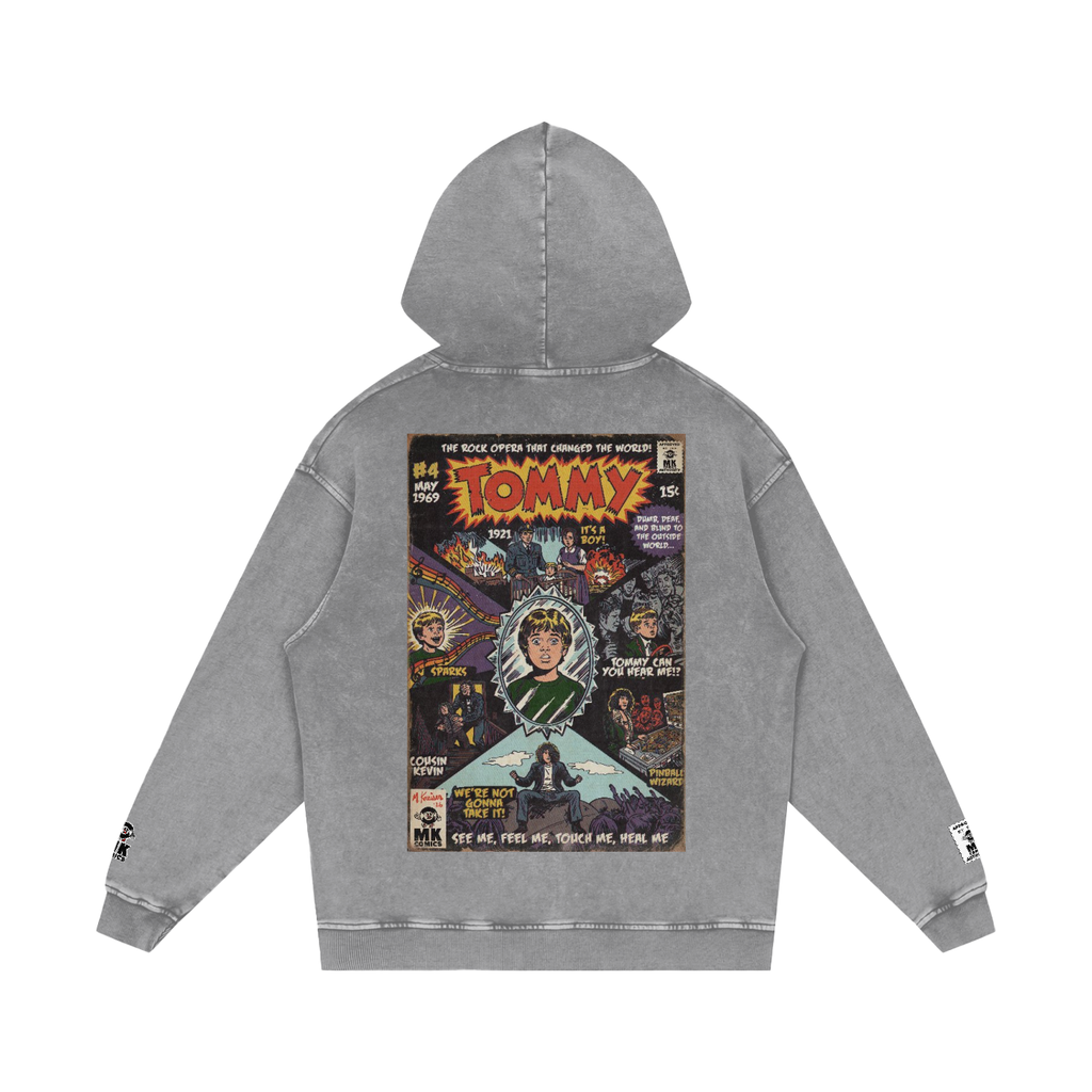 A gray mineral-wash hoodie shown from the back, featuring a large vintage comic book cover graphic by MK Comics Parody Art with the word 'TOMMY' by the Who in bold yellow letters and various illustrated characters.