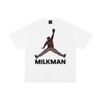 A white short-sleeve crewneck t-shirt featuring a graphic of Colton Cowser in orange and black orioles jersey mid-homerun rob, with the word 'MILKMAN' printed in bold black letters underneath.